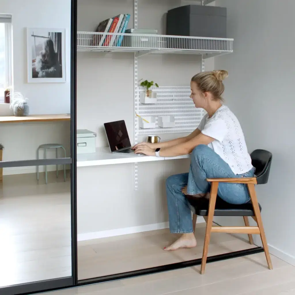 Domácí kancelář zakomponovaná do vestavěné šatní skříně v rámci řady Classic by Elfa.